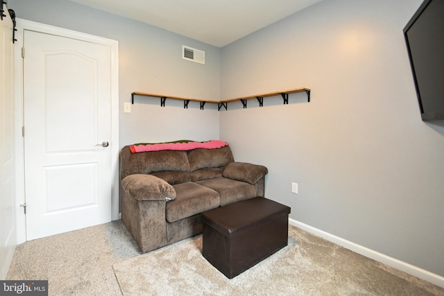 sitting room with baseboards, a barn door, visible vents, and carpet floors