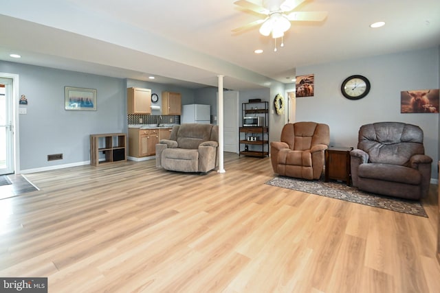 living room with baseboards, recessed lighting, light wood-style floors, and ceiling fan