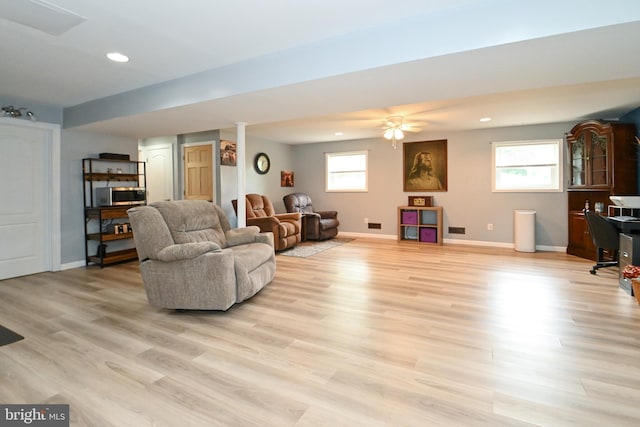living area with light wood-style floors, baseboards, a healthy amount of sunlight, and recessed lighting