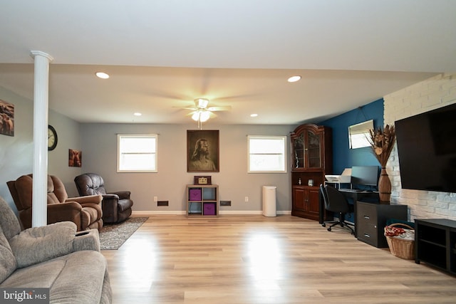 living room featuring light wood-type flooring, plenty of natural light, decorative columns, and recessed lighting
