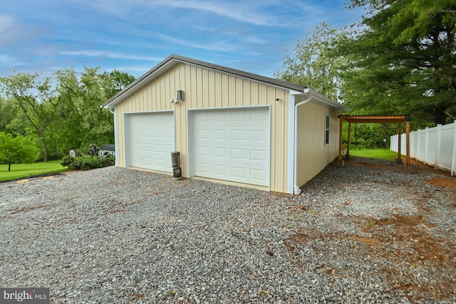 detached garage with fence and gravel driveway