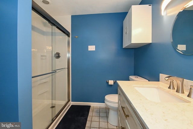 full bathroom with toilet, vanity, a stall shower, tile patterned flooring, and baseboards