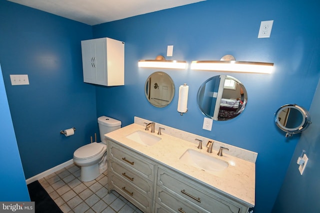 full bathroom featuring toilet, tile patterned flooring, double vanity, and a sink