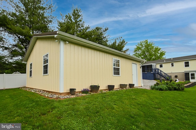 view of property exterior featuring fence and a lawn