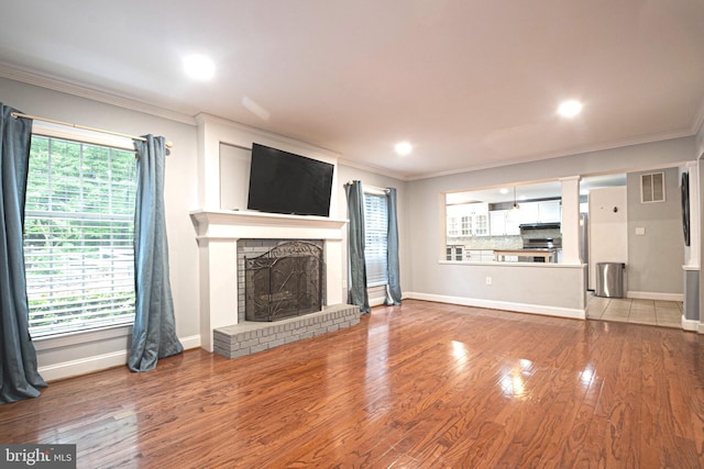 9190 Balsam Run, Bel Alton, MD 20611 - unfurnished living room featuring baseboards, visible vents, a brick fireplace, crown molding, and wood finished floors