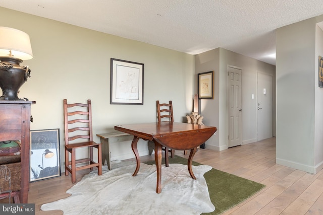 office space featuring a textured ceiling, baseboards, and wood finished floors