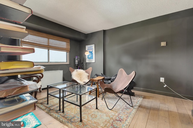 sitting room featuring hardwood / wood-style flooring and a textured ceiling
