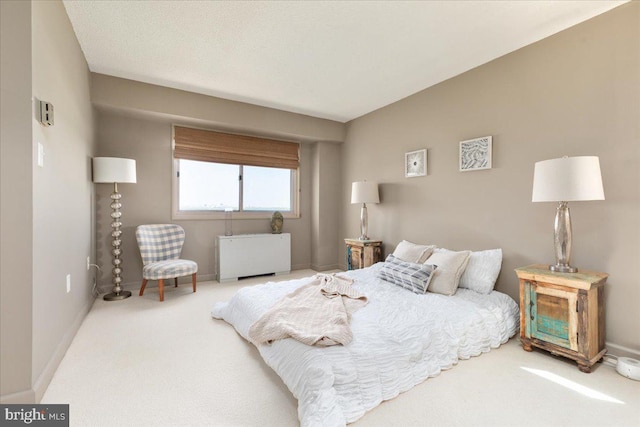 bedroom with baseboards, radiator, and carpet flooring
