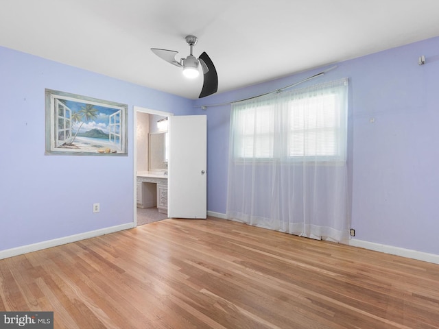 unfurnished bedroom featuring ceiling fan, light wood-style flooring, and baseboards