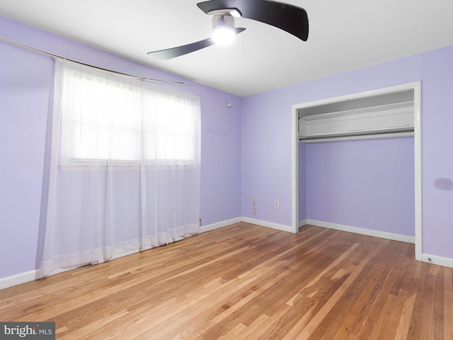 unfurnished bedroom featuring baseboards, a closet, ceiling fan, and wood finished floors