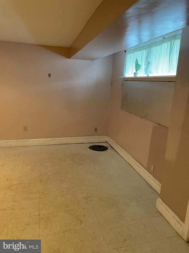 below grade area with baseboards and tile patterned floors