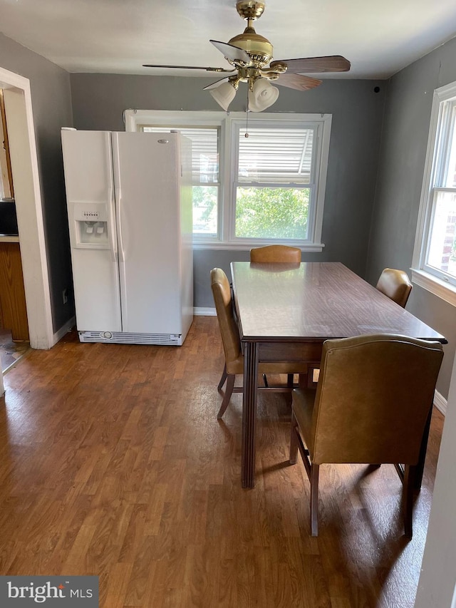 dining area featuring baseboards, ceiling fan, and wood finished floors
