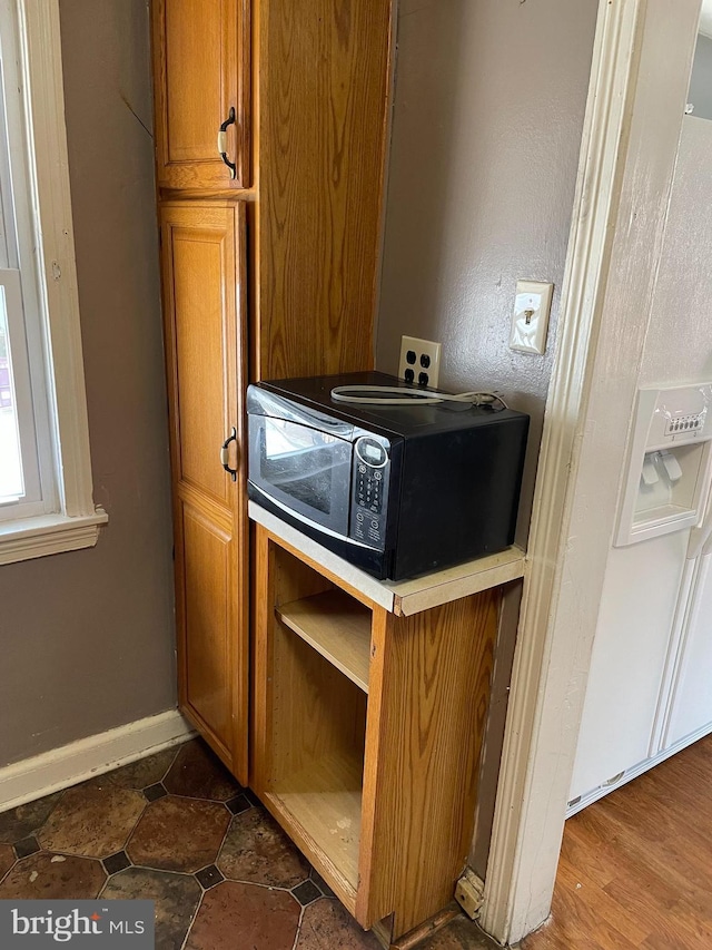 interior details with baseboards and black microwave