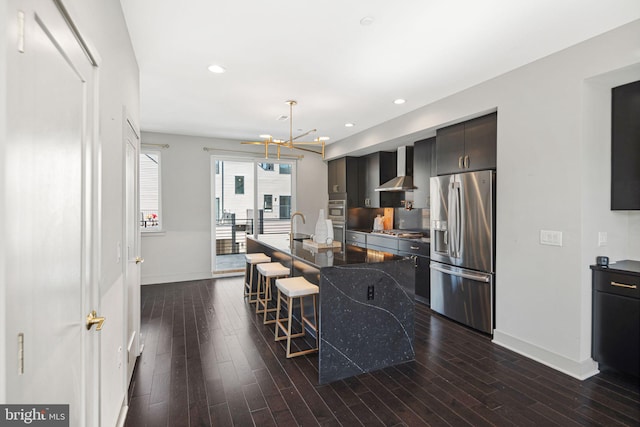 670 N 13th St, Philadelphia, PA 19123 - kitchen featuring appliances with stainless steel finishes, a breakfast bar, wall chimney exhaust hood, dark wood-style floors, and a kitchen island with sink