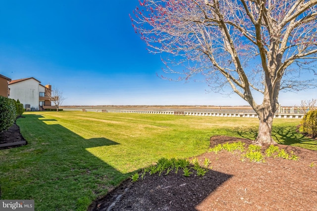 view of green lawn featuring a water view