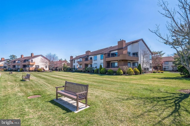 view of home's community featuring a lawn and a residential view