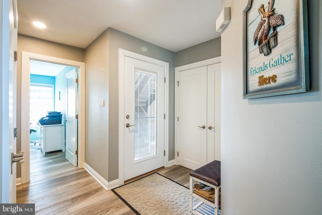 doorway to outside with light wood-style flooring and baseboards
