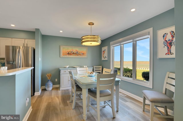 dining room with light wood-style flooring, baseboards, and recessed lighting