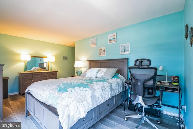 bedroom with wood finished floors and a desk