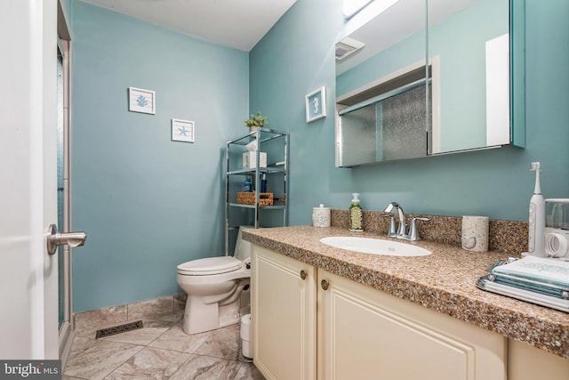 full bath featuring toilet, vanity, and a shower with door