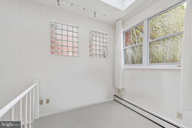 328 S Juniper St, Philadelphia, PA 19107 - spare room with rail lighting, carpet floors, baseboards, and a baseboard heating unit