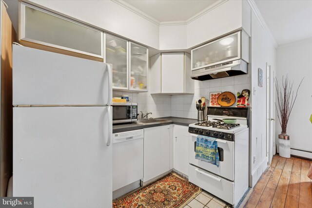 328 S Juniper St, Philadelphia, PA 19107 - kitchen featuring a sink, dark countertops, white appliances, under cabinet range hood, and ornamental molding