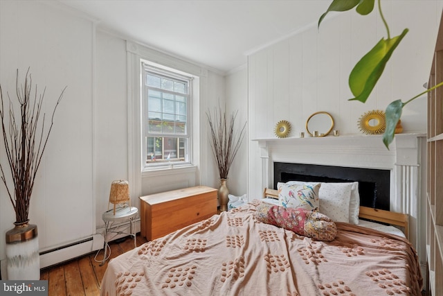 328 S Juniper St, Philadelphia, PA 19107 - bedroom featuring hardwood / wood-style floors, a fireplace, crown molding, and a baseboard radiator