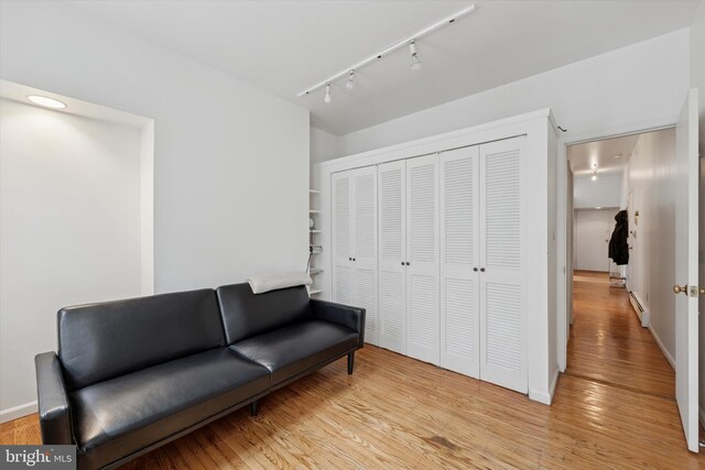 328 S Juniper St, Philadelphia, PA 19107 - living area with track lighting, light wood-style flooring, baseboards, and a baseboard heating unit