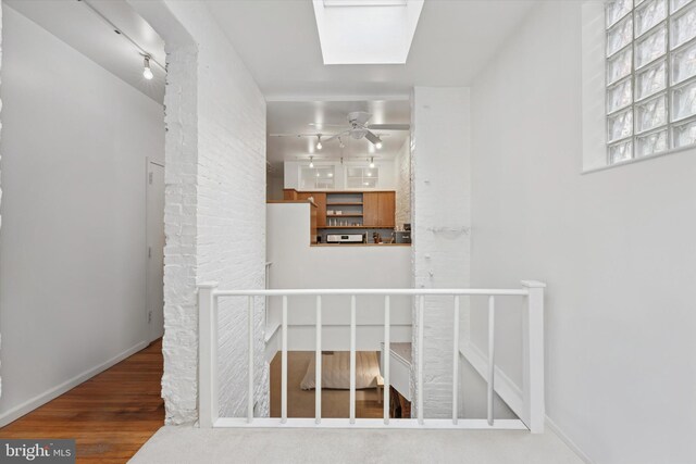 328 S Juniper St, Philadelphia, PA 19107 - interior space with rail lighting, a skylight, an upstairs landing, and wood finished floors