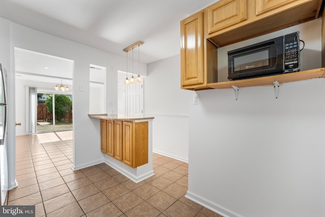 kitchen featuring a chandelier, black microwave, light tile patterned floors, baseboards, and decorative light fixtures