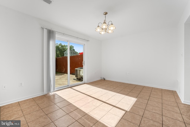 unfurnished room featuring a chandelier, light tile patterned floors, and baseboards