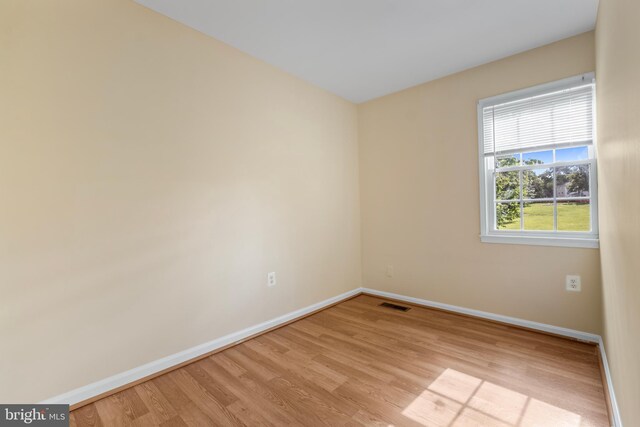 spare room featuring baseboards and light wood-type flooring