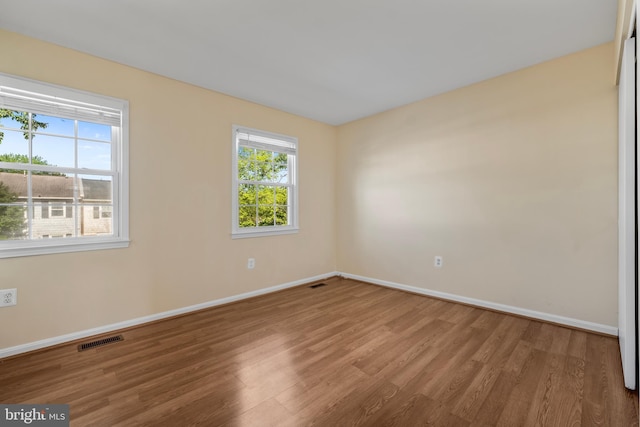 empty room with wood finished floors and baseboards