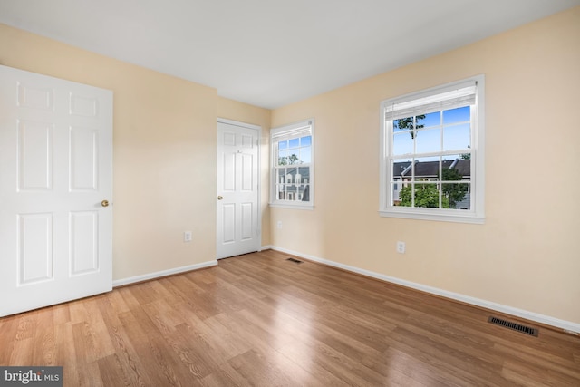 unfurnished bedroom with wood finished floors, baseboards, and a closet