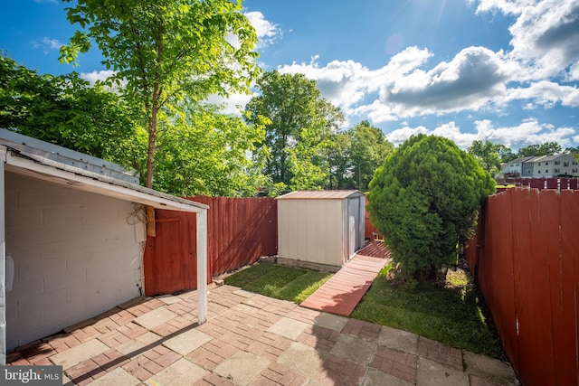 view of patio featuring a shed, a fenced backyard, and an outdoor structure