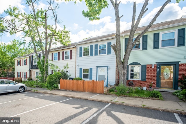 view of property with uncovered parking and fence