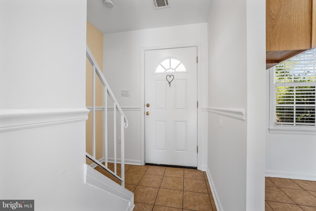foyer entrance featuring tile patterned flooring, healthy amount of natural light, and baseboards