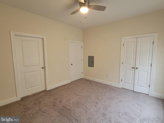 unfurnished bedroom featuring carpet floors, baseboards, ceiling fan, and electric panel