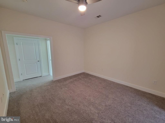 carpeted empty room with baseboards, ceiling fan, and visible vents