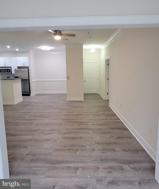 unfurnished living room with ornamental molding, wood finished floors, baseboards, ceiling fan, and recessed lighting
