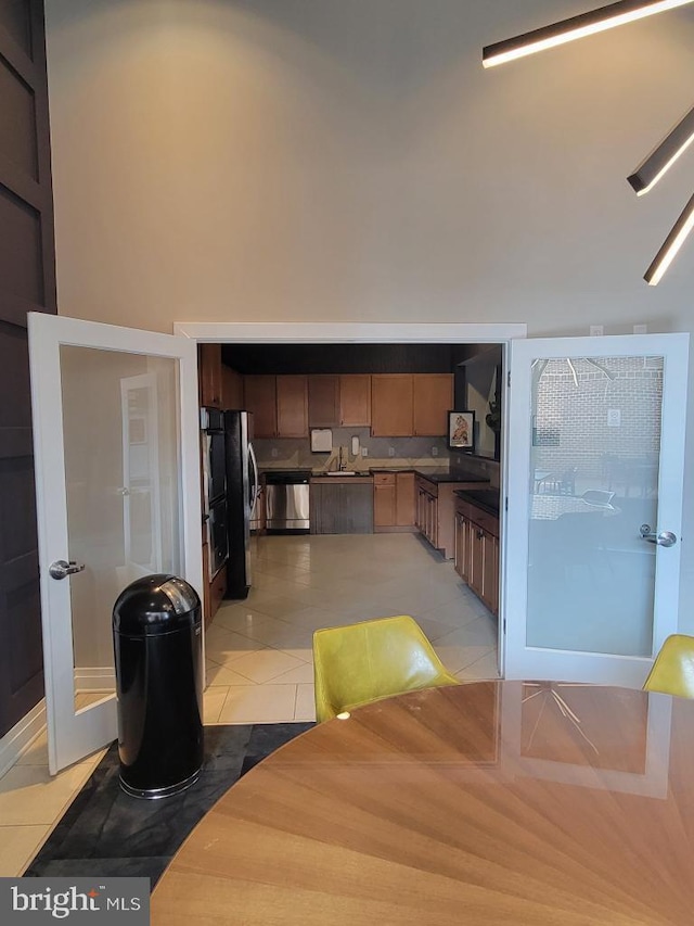 kitchen with stainless steel appliances, a sink, and light tile patterned floors
