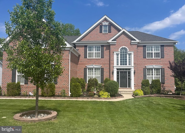 view of front of property featuring brick siding and a front lawn