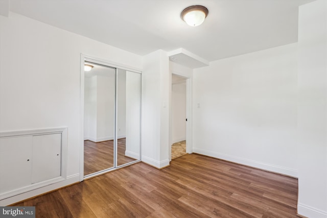 101 Oakmont Ct NE, Vienna, VA 22180 - unfurnished bedroom with wood finished floors, a closet, and baseboards