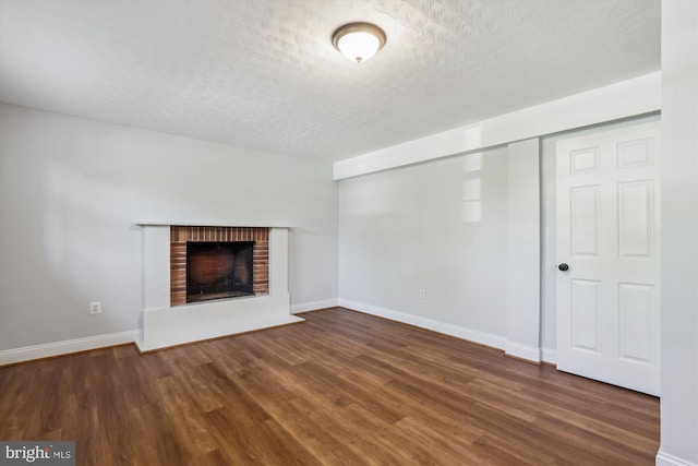 101 Oakmont Ct NE, Vienna, VA 22180 - unfurnished living room featuring wood finished floors, a textured ceiling, a fireplace, and baseboards