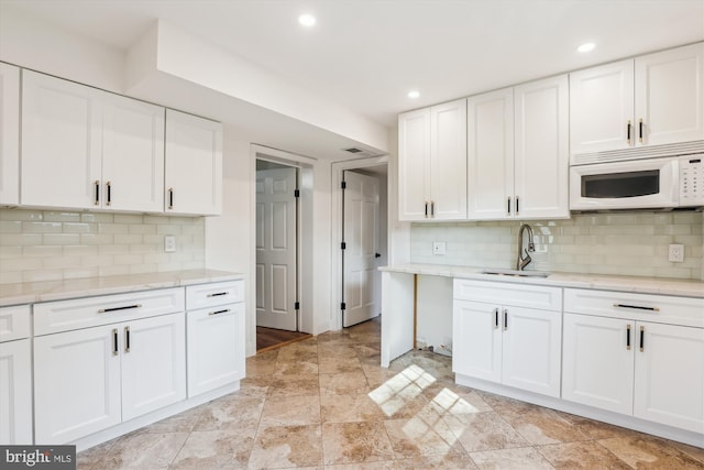 101 Oakmont Ct NE, Vienna, VA 22180 - kitchen with white microwave, a sink, white cabinets, decorative backsplash, and recessed lighting