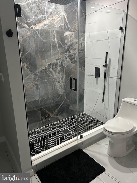 bathroom with toilet and a stall shower