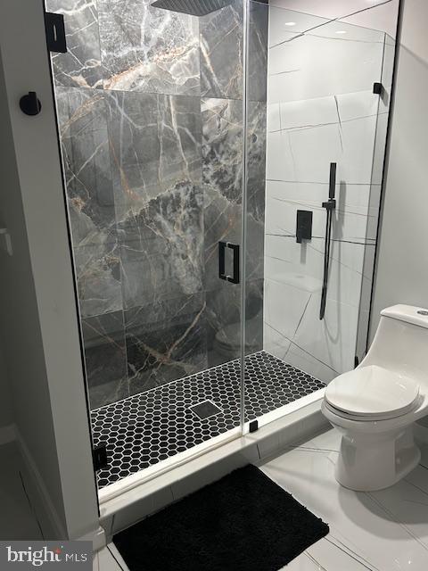 bathroom with toilet and a stall shower