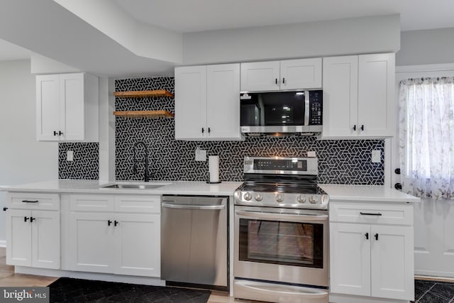 kitchen featuring appliances with stainless steel finishes, a sink, backsplash, and light countertops