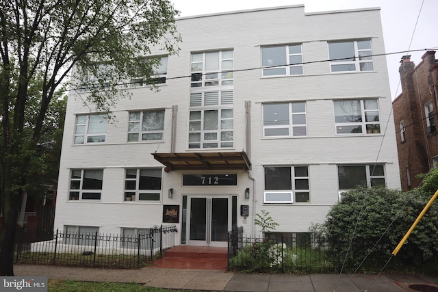 712 Marietta Pl NW Unit 104, Washington, DC 20011 - view of front of home featuring brick siding and a fenced front yard