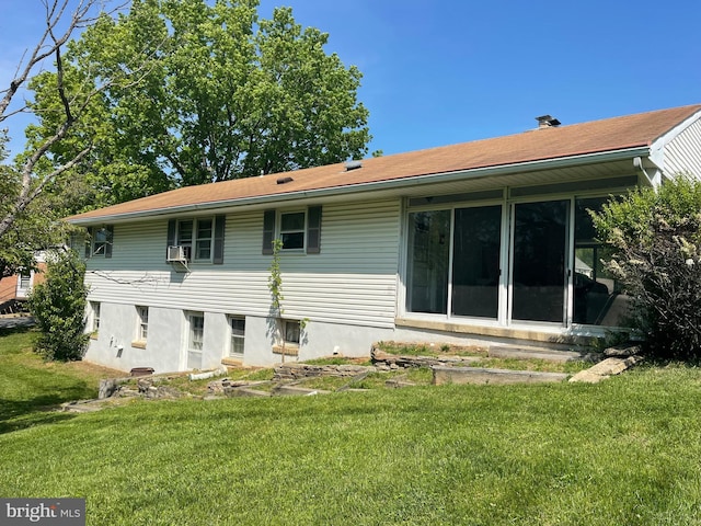 rear view of house with a lawn and cooling unit